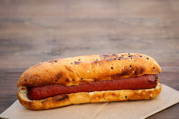Fresh tasty hot dog on wooden table, closeup