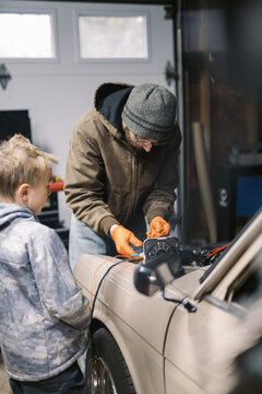 Father and son working on an old car 