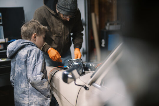 Father and son working on an old car 