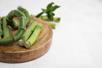Pieces of beautiful green bamboo stems on white tiled table, closeup. Space for text