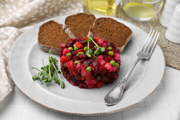 Delicious vinaigrette salad with slices of bread on white table