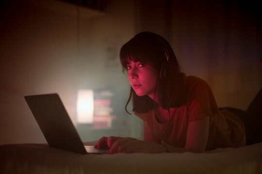 Woman using laptop on bed
