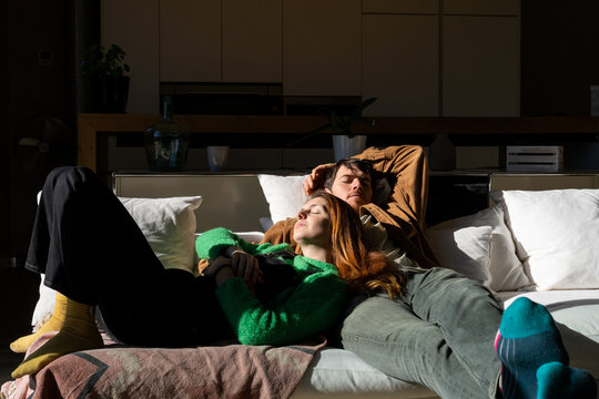 couple sleeping and hugging on sofa 