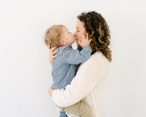 happy mother and toddler giving her a kiss on the nose 