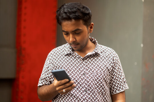Young Indian male speaking on a smartphone at outdoors in a street
