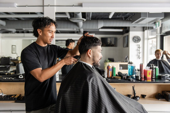 Barber Cuts Hair In Busy Barbershop
