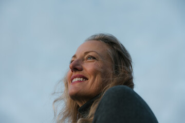 Mature woman feeling spiritual alone at sunset.