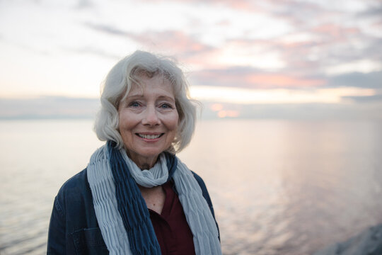 Healthy mature woman looking at the camera for sunset portrait.