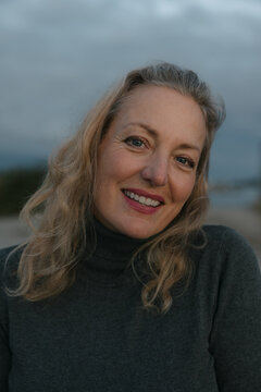 Healthy mature woman looking at the camera for sunset portrait.