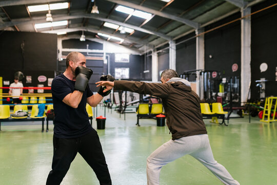 Male boxer training with coach