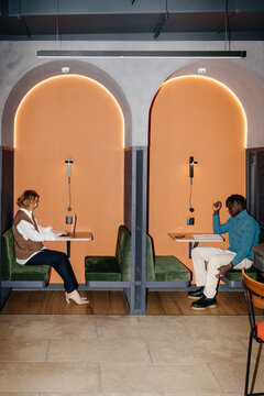Multiracial man and woman working in cubicles