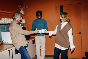 Colleagues having fun during break in office kitchen