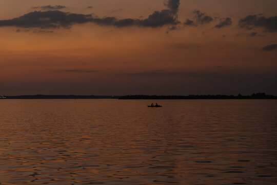 Silhouette Of Two People Sailing In A Boat