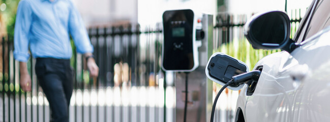 Focus closeup electric vehicle recharge battery at public charging station in the city area with...