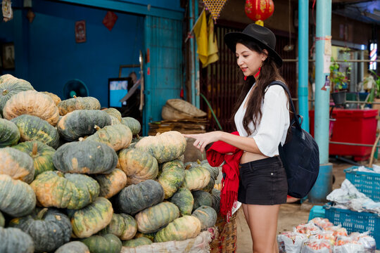 A woman looks at pumpkins inside a food market