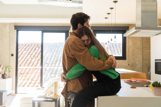 Couple hugging at kitchen