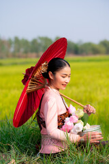 Pretty Asian women in traditional Thai dress. Beautiful traditional Thai dresses by Asian Buddhists make merit at the Temple a tourist attraction, a