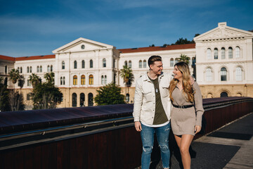 Beloved young couple smiling ad walking on street