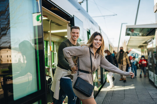 Happy young couple getting off train and smiling