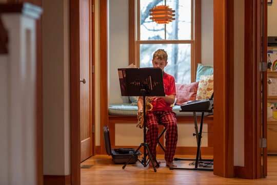 Young boy portrait  at home playing saxophone  instrument 