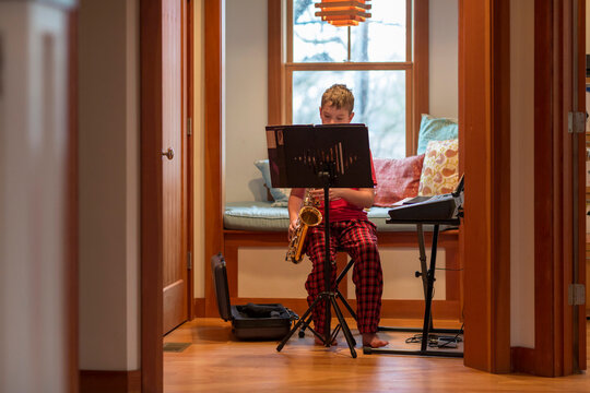 Young boy portrait  at home playing saxophone music