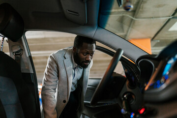 Black driver checking car dashboard