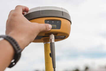 A surveyor sets up a Global Navigation Satellite System or GNSS Receiver. Real-time kinematic or RTK geodetic surveying equipment used in the field. - obrazy, fototapety, plakaty