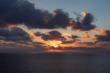 dark blue sea water surface and dramatic orange sky at sunset