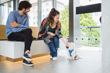Young woman caressing dog in clinic