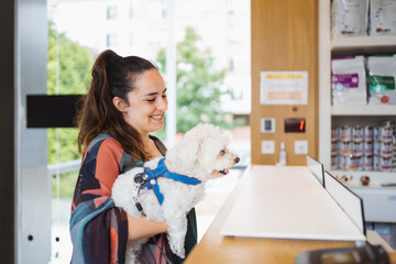 Woman with dog at counter in vet