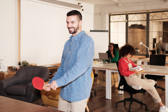 Employee playing ping pong at modern office