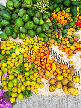 Top view of oranges, chayote, pears and seasonal fruits on a petate