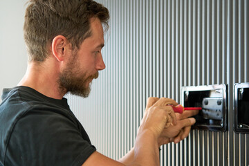 Electrician fitting TV switch box