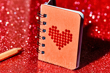 red notepad with a red heart, and pencil