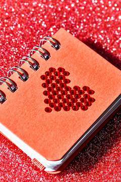 red heart in the cover of a red notepad