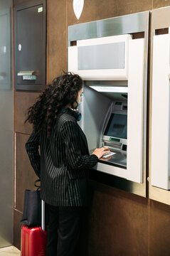 Young woman using ATM machine