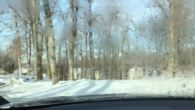 deicing windshield with deicer fluid in winter