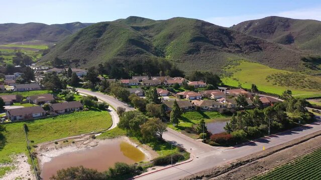 2023 - Excellent aerial footage of houses nestled between mountains and farmland in Lompoc, California.