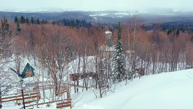 View of the chapel near the Belogorsky St. Nicholas Orthodox Missionary Monastery. Winter forest. The temple on the hill in winter. Russia, Perm Krai, Belaya Gora. 4K