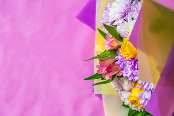 Bright bouquet of flowers on a pink background.Flat lay photo from above. There is space for text. 