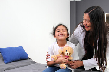 8-year-old Latino girl patient in the office of a pediatric specialist doctor there is confidence,...