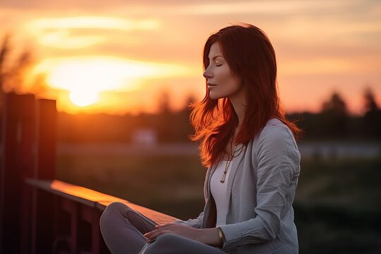 Woman meditating outside at sunset