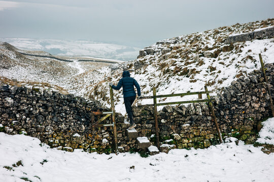 Walker crossing wall stile near malham cove