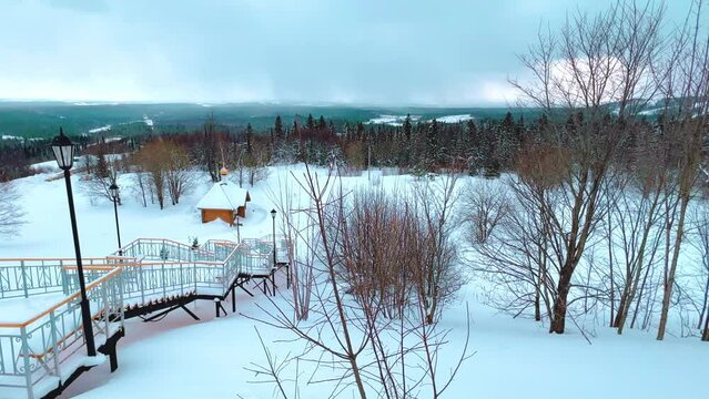 View of the chapel near the Belogorsky St. Nicholas Orthodox Missionary Monastery. Winter forest. The temple on the hill in winter. Russia, Perm Krai, Belaya Gora. 4K