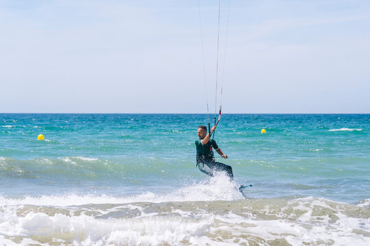 Kiteboarder on waving surface of sea