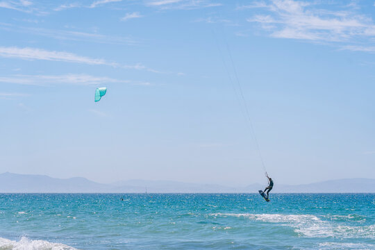 Tourist practicing kiteboarding on sea waves