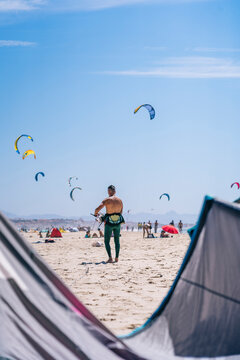 Tourist beach with people kitesurfing