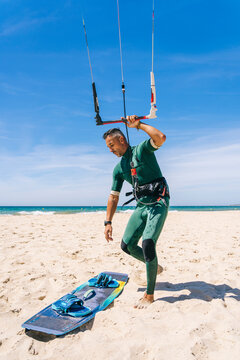 Man practicing kite surfing on beach