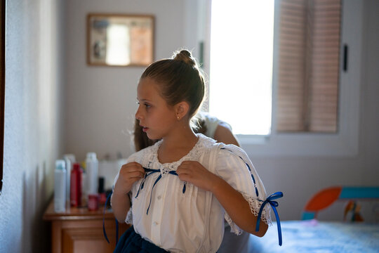 Grandmother dressing her granddaughter