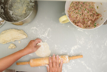 Grandma's hands rolling dumpling dough